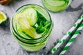 Infused detox water with cucumber, lemon and lime. Refreshing ice cold summer cocktail or lemonade in glass Royalty Free Stock Photo