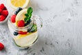 Infused detox water with lemon slice, raspberry, blueberry and mint. Ice cold summer cocktail or lemonade in mason jar Royalty Free Stock Photo