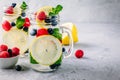 Infused detox water with lemon slice, raspberry, blueberry and mint. Ice cold summer cocktail or lemonade in mason jar Royalty Free Stock Photo