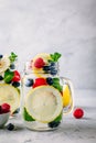 Infused detox water with lemon slice, raspberry, blueberry and mint. Ice cold summer cocktail or lemonade in mason jar Royalty Free Stock Photo