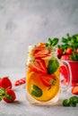 Infused detox water with orange, strawberry and mint. Ice cold summer cocktail or lemonade. Royalty Free Stock Photo