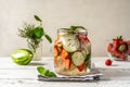 Infused water in glass jar with ingredients - strawberry, meloncella that is hybrid of cucumber and melon, thyme, mint. Royalty Free Stock Photo