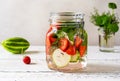 Infused water in glass jar made with strawberry and meloncella that is hybrid of cucumber and melon, thyme, mint. Royalty Free Stock Photo