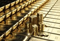 Ingots gold bars stacked aligned with some piles of gold dollar coins