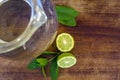Ingredient for fresh cocktail - mint leaves and lemon near glass jar of water or soda