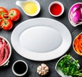 Ingredientes for cooking peruvian dish Lomo saltado - tenderloin beef, vegetables around white plate. Tot view Royalty Free Stock Photo