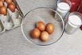 Ingredients for baking cake on a table. Cooking set. Open box with tinted brown chicken eggs, four eggs in a transparent bowl,