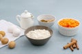 Ingredients for baking carrot cake. Flour, grated carrots, eggs, milk, walnuts, spices are located on the kitchen table in gray. Royalty Free Stock Photo