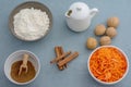 Ingredients for baking carrot cake. Flour, grated carrots, milk, walnuts, spices are located on the kitchen table in gray. Carrot Royalty Free Stock Photo