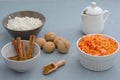 Ingredients for baking carrot cake. Flour, grated carrots, milk, walnuts, spices are located on the kitchen table in gray. Carrot Royalty Free Stock Photo