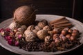 ingredients for baking, cinnamon sticks, star anise, cloves, nuts, coconut, coffee beans on a wooden background