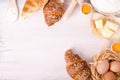 Ingredients for baking croissants - flour, wooden spoon, rolling pin, eggs, egg yolks, butter served on white background Royalty Free Stock Photo