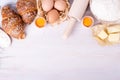 Ingredients for baking croissants - flour, wooden spoon, rolling pin, eggs, egg yolks, butter served on white background Royalty Free Stock Photo