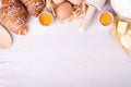 Ingredients for baking croissants - flour, wooden spoon, rolling pin, eggs, egg yolks, butter served on white background Royalty Free Stock Photo