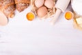 Ingredients for baking croissants - flour, wooden spoon, rolling pin, eggs, egg yolks, butter served on white background Royalty Free Stock Photo