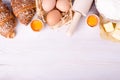 Ingredients for baking croissants - flour, wooden spoon, rolling pin, eggs, egg yolks, butter served on white background Royalty Free Stock Photo