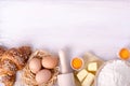 Ingredients for baking croissants - flour, wooden spoon, rolling pin, eggs, egg yolks, butter served on white background Royalty Free Stock Photo