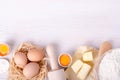 Ingredients for baking croissants - flour, wooden spoon, rolling pin, eggs, egg yolks, butter served on white background Royalty Free Stock Photo