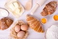 Ingredients for baking croissants - flour, wooden spoon, rolling pin, eggs, egg yolks, butter served on white background Royalty Free Stock Photo