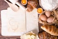 Ingredients for baking croissants - paper, flour, wooden spoon, rolling pin, eggs, egg yolks, butter served on a rustic Royalty Free Stock Photo