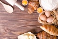 Ingredients for baking croissants - paper, flour, wooden spoon, rolling pin, eggs, egg yolks, butter served on a rustic Royalty Free Stock Photo