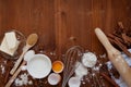 Ingredients for baking dough including flour, eggs, milk, butter, sugar, cinnamon, anise star, whisk and rolling pin on wooden Royalty Free Stock Photo