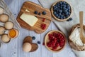 Ingredients for baking lie on a light wooden background with a blue kitchen towel. butter, berries and wooden Royalty Free Stock Photo