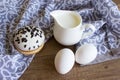 Ingredients for breakfast. Donut with white shekolad and milk shavings. White milkman, two chicken eggs