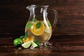 Ingredients for a citrus lemonade on a wooden background. Lime, oranges, mint next to a jar of fruit juice. Cafe drinks. Royalty Free Stock Photo