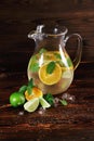 Ingredients for a citrus lemonade on a wooden background. Lime, oranges, mint next to a jar of fruit juice. Cafe drinks. Royalty Free Stock Photo