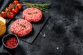 Ingredients for cooking burgers. Minced beef patties, buns, tomatoes, herbs and spices. Black background. Top view. Copy space Royalty Free Stock Photo