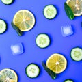 Ingredients for cooking cold spring lemonade drink with cucumber, pieces of lemon, fresh leaves mint ice cubes on blue background Royalty Free Stock Photo