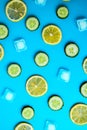 Ingredients for cooking cold spring lemonade drink with cucumber, pieces of lemon, ice cubes on blue background, top view Royalty Free Stock Photo