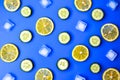 Ingredients for cooking cold spring lemonade drink with cucumber, pieces of lemon, ice cubes on blue background, top view Royalty Free Stock Photo