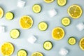 Ingredients for cooking cold spring lemonade drink with cucumber, pieces of lemon, ice cubes on blue background, top view Royalty Free Stock Photo