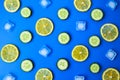 Ingredients for cooking cold spring lemonade drink with cucumber, pieces of lemon, ice cubes on blue background, top view Royalty Free Stock Photo