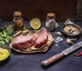 Ingredients for cooking concept Preparation of two steak of turkey lemon herb seasoning garlic hot red pepper and knife wooden