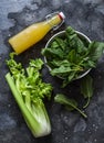 Ingredients for cooking detox diet green smoothies - fresh celery, spinach, natural orange juice on a dark background, top view Royalty Free Stock Photo