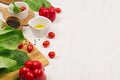 Ingredients for cooking fresh raw spring salad of green and red vegetables, spices, oil with wooden kitchenware on white wood back Royalty Free Stock Photo