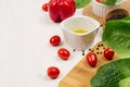 Ingredients for cooking fresh raw spring salad of green and red vegetables, spices, oil with wooden kitchenware on white wood back Royalty Free Stock Photo