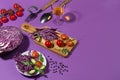 Ingredients for cooking of fresh summer vegetable salad with red cabbage, cherry tomato, cucumber in hard light on purple. Royalty Free Stock Photo