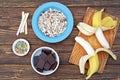 Ingredients for cooking frozen bananas in chocolate on wooden background