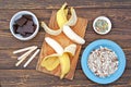 Ingredients for cooking frozen bananas in chocolate on wooden background