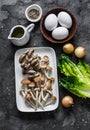 Ingredients for cooking healthy breakfast, brunch - egg, mixed mushrooms and green salad on a dark background, top view Royalty Free Stock Photo