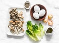 Ingredients for cooking healthy breakfast, brunch - egg, mixed mushrooms and green salad on a light background, top view Royalty Free Stock Photo