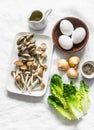 Ingredients for cooking healthy breakfast, brunch - egg, mixed mushrooms and green salad on a light background, top view Royalty Free Stock Photo