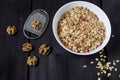 Ingredients for cooking healthy breakfast. Nuts, oat flakes, dried fruits, honey, granola, wooden heart in a white bowl. Royalty Free Stock Photo