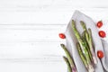 Ingredients for cooking healthy breakfast: fresh asparagus, tomatoes on white table. Rustic style composition. Flat lay, top view Royalty Free Stock Photo