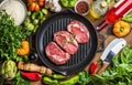 Ingredients for cooking healthy meat dinner. Raw uncooked beef steaks with vegetables, rice, herbs, spices and wine Royalty Free Stock Photo