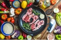 Ingredients for cooking healthy meat dinner. Raw uncooked lamb chops in iron grill pan with vegetables, rice, herbs and